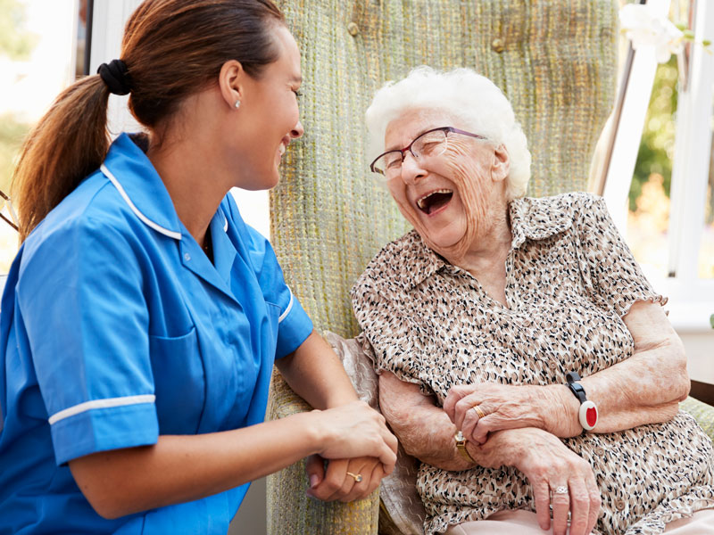 senior woman laughing with caregiver